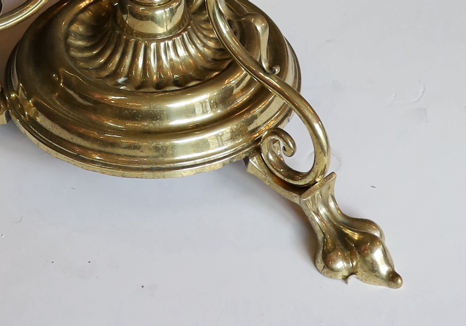 An Edwardian brass telescopic oil lamp standard, with later edged cranberry glass shade and duplex mechanism, height 168cm. width 52cm